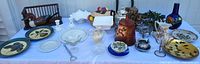 Full lot overview on table showing quantity and variety of ceramics, glass, metal and wood items