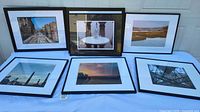 All six framed photographic prints arranged on table, front view