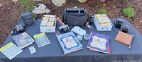 Overhead view of entire lot on table showing cameras, slide boxes, lens, playbill magazines, bags and accessories
