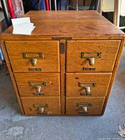 Front view showing 6 drawers, brass hardware, brand plate