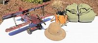 Group shot of biplane, duffel, binoculars, pith helmet
