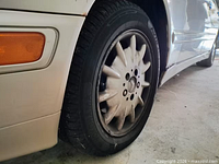 Front driver-side wheel, tire, and oxidized headlight visible showing wear