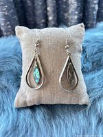 Front view of both teardrop abalone inlay earrings on display cushion