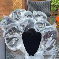 Group of nine black velvet necklace display busts, several still in plastic wrap