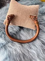 Full view of copper/bronze open cuff bracelet with ram head terminals