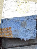 Overall view of doilies spread on bins showing variety of patterns and colors