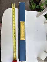 Blue rectangular box of taper candles beside tape measure showing 12 in length