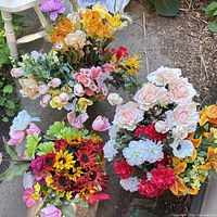 Overall view of multiple mixed artificial flower bouquets on ground