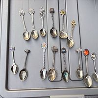 All 14 spoons laid out showing size, finishes, handle designs