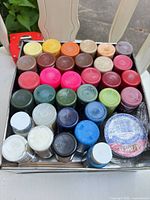 Top view showing 32 assorted 2 fl oz paint bottles arranged in tray