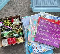 Overview of boxed ribbons and bows with stacks of packaged wrapping paper sheets