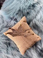 Brooch on burlap cushion showing front design and finish