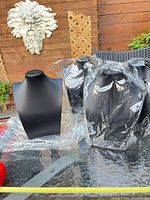 Front view of one necklace display bust with others wrapped in plastic