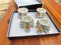 Four porcelain candle holders in box