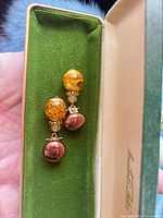 Earrings displayed in green velvet-lined box showing overall design
