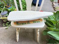 Overall view of sleeve ironing board on chair showing top cover and size
