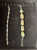 Two bracelets on display tray highlighting abalone bracelet design and length