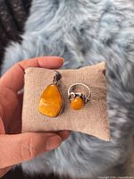 Front view of both amber ring and pendant on cushion