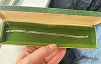 Bracelet laid flat in green-lined case showing full length and link style