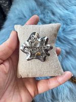 Front view showing abstract floral filigree design and polished/oxidized finish