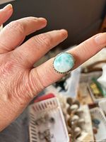 Ring worn on finger showing oval Larimar stone
