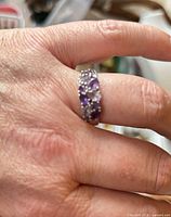 Ring worn on hand showing cluster of amethyst and CZ across band