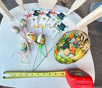 Entire lot displayed with ruler for scale: paper-mache egg, egg picks, bunny decorations, honeycomb eggs