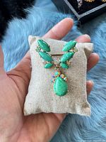 Front view showing green cabochons, AB rhinestones and dangle