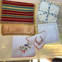 Exterior of crocheted pouch and three napkins displayed