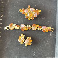 Set laid out showing bracelet, brooch and earrings front view