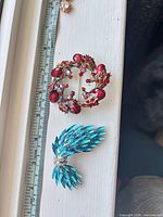 Top-down view showing both brooches with ruler for scale