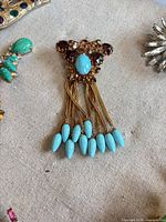 Front view showing amber rhinestones, turquoise cabochon, tassel beads