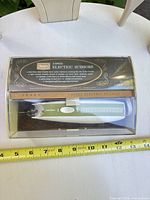 Scissors in clear-top case with Sears branding and ruler for scale