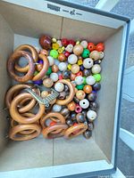 Box containing wooden rings, metal eyes, assorted beads