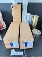 Overall lot showing two Epson boxed rolls, additional boxed roll, three loose metallic rolls, Kodak film tank