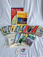 Full lot showing two atlases and large spread of folded maps/trail guides