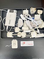 Tray with assorted AC plug adapters, power bank, wall cube, car charger, cable