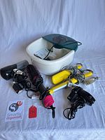 Group shot of all items including foot spa, hair dryers, Drybar tools, hot air brush and cords
