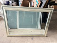 Front view showing silver wood frame and reflective glass