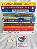 Stack of 12 books plus lot tag showing spines for title and format identification