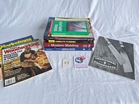 Full lot overview with stacked books and magazines on white surface