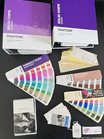 Pantone Solid Chips boxed sets, Pantone Formula Guide, Pantone Metallics fan deck, Pantone mini guide, Epson sample guide booklet, assorted small swatch cards