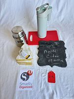 Group shot showing all items: thermos, water bottle, cutting board, slate sign, stacked coasters