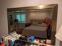 Front view of mirror reflecting bedroom setup