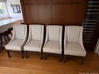 Four matching beige linen-look Parsons chairs