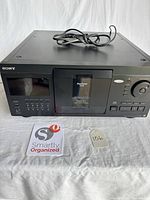 Front view of Sony CDP-CX90ES showing controls, display, door, and power cord