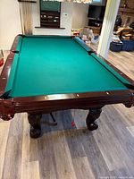 Pool table full view showing green felt, mahogany frame, leather pockets
