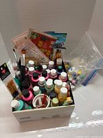 Box containing paint bottles, brushes, accessories