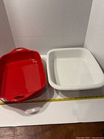 Top view red and white baking dishes side by side with tape measure