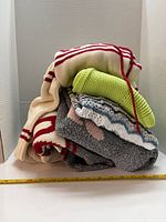Pile of five sweaters showing colors and textures